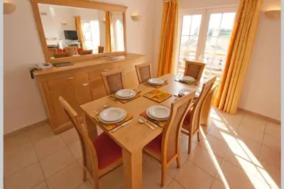a dining room with a table with chairs and a laptop at Luxury private property-pool, unique sun roof, free wifi in Budens
