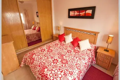 a bedroom with a bed with red pillows and a mirror at Luxury private property-pool, unique sun roof, free wifi in Budens