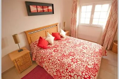 a bedroom with a red and white bed with red pillows at Luxury private property-pool, unique sun roof, free wifi in Budens