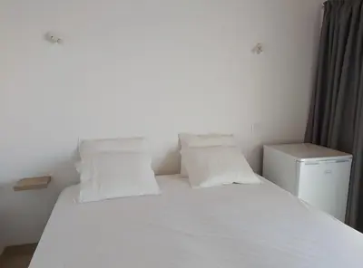 a bedroom with a white bed with two pillows at Monte Bagão - Turismo Rural in Vila do Bispo