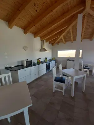 a kitchen with white cabinets and a table and chairs at Monte Bagão - Turismo Rural in Vila do Bispo