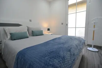 a bedroom with a large bed with a blue blanket at Casas do Baleeiro - Whaler's Houses by Rentery Madeira in Caniçal