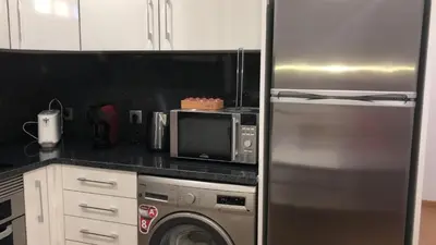 a kitchen with a stainless steel refrigerator and a microwave at Casas do Baleeiro - Whaler's Houses by Rentery Madeira in Caniçal