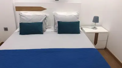 a bedroom with a bed with blue and white pillows at Casas do Baleeiro - Whaler's Houses by Rentery Madeira in Caniçal