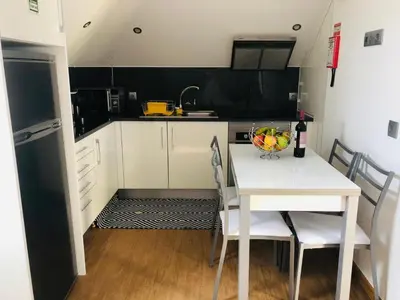 a kitchen with a white table with a bowl of fruit on it at Casas do Baleeiro - Whaler's Houses by Rentery Madeira in Caniçal