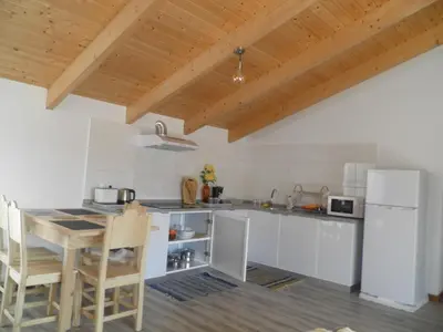 a kitchen with a table and a white refrigerator at Villa Luz II - NEW - Private Outdoor Area in Santa Cruz