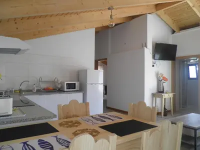 a kitchen with a table and a white refrigerator at Villa Luz II - NEW - Private Outdoor Area in Santa Cruz
