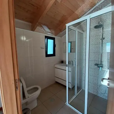 a bathroom with a toilet and a glass shower at Villa Luz II - NEW - Private Outdoor Area in Santa Cruz