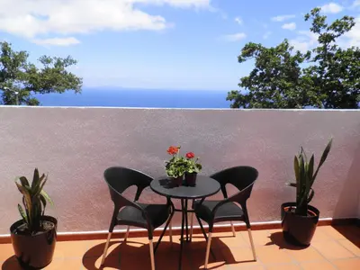 a table and chairs on a balcony with plants at Villa Luz II - NEW - Private Outdoor Area in Santa Cruz