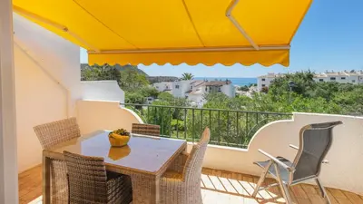 a table and chairs on a balcony with an umbrella at Vila Vista Luz in Lagos