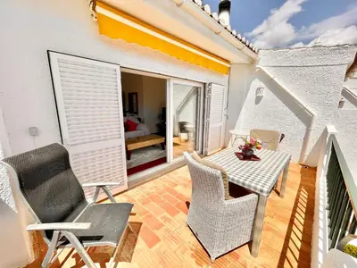 a living room with a view of the ocean from a balcony at Vila Vista Luz in Lagos