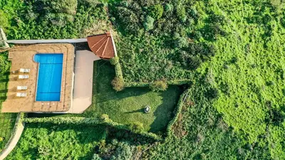 an overhead view of a house in a field at Secluded Sunset Villa on Cliff & 180 Degree Ocean Views in Fajã da Ovelha