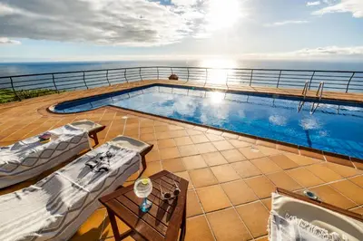 a swimming pool on the deck of a cruise ship at Secluded Sunset Villa on Cliff & 180 Degree Ocean Views in Fajã da Ovelha