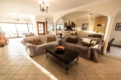 a living room with a couch and a table at Secluded Sunset Villa on Cliff & 180 Degree Ocean Views in Fajã da Ovelha