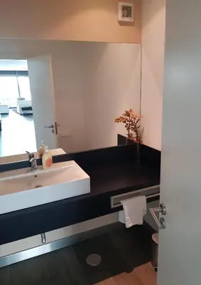 a bathroom with a white sink and a mirror at Sunshine Villa with Optionally Heated Pool 150m above Ocean & Sandy Beach in Estreito da Calheta