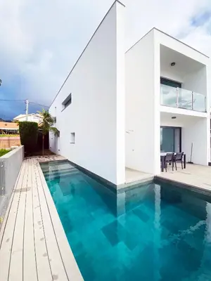 a white house with a swimming pool at Sunshine Villa with Optionally Heated Pool 150m above Ocean & Sandy Beach in Estreito da Calheta