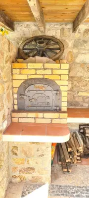 a stone fireplace in a stone wall with a wheel at Catavento in Porto Santo