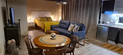 a living room with a bed and a table and a room at Catavento in Porto Santo