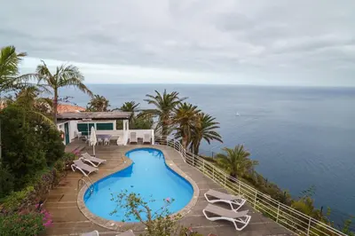 a view of a swimming pool and the ocean at Vila da Falésia-With Pool and views in Caniço