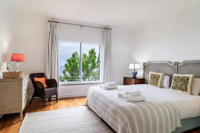 a bedroom with a large bed and a large window at Vila da Falésia-With Pool and views in Caniço