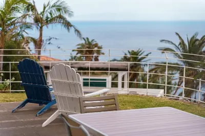 two chairs and a table on a balcony overlooking the ocean at Vila da Falésia-With Pool and views in Caniço