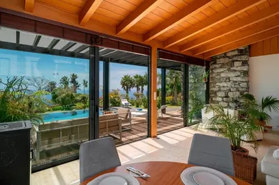 a dining room with a view of a swimming pool at OurMadeira - Garden Paradise in Calheta