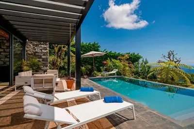 a villa with a swimming pool and a patio at OurMadeira - Garden Paradise in Calheta