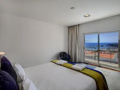 a bedroom with a bed and a large window at The White House - By LovelyStay in Funchal