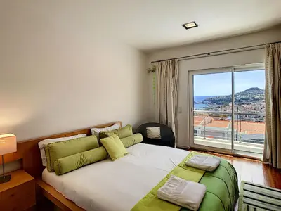 a bedroom with a large bed with a large window at The White House - By LovelyStay in Funchal