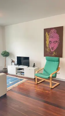 a living room with a green chair and a tv at Funchal Centrum Apartment in Funchal