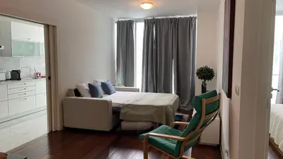 a bedroom with a bed and a green chair at Funchal Centrum Apartment in Funchal