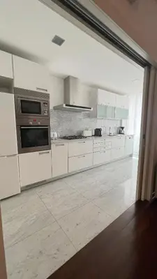 a large kitchen with white cabinets and appliances at Funchal Centrum Apartment in Funchal