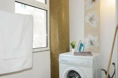 a washing machine in a bathroom with a window at Sol do Lido in Funchal