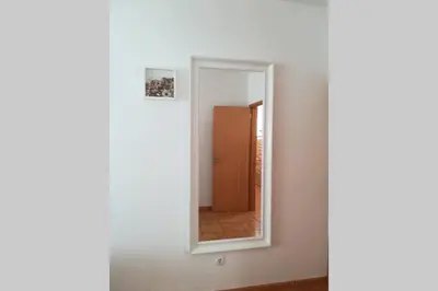 a mirror on a wall next to a hallway at Casa das Flores in Vila do Bispo