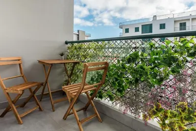 two chairs and a table on a balcony at FLH Funchal Nature Flat with Balcony in Funchal