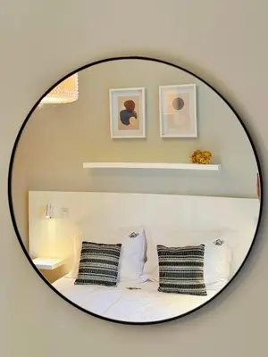 a mirror reflecting a bed with two pillows at Quinta do Ribeiro Salgado's Beach House in Porto Santo