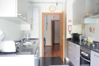 a kitchen with white cabinets and a clock on the wall at Angel's Apartment in Funchal
