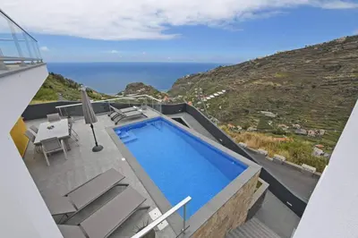 a villa with a swimming pool and a view of the ocean at Villa Golden Charm in Tábua