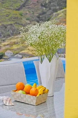 a table with a basket of oranges and a vase of flowers at Villa Golden Charm in Tábua