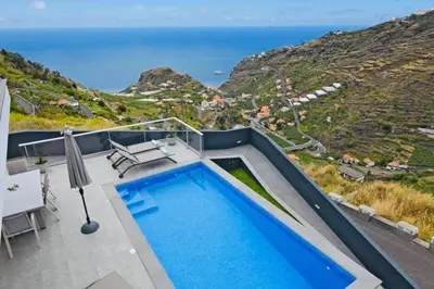a pool on the roof of a house with a view of the ocean at Villa Golden Charm in Tábua