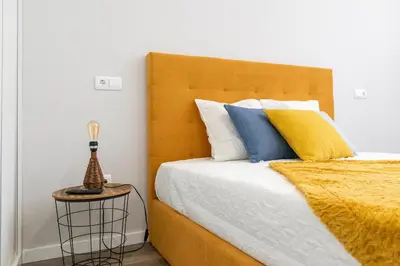 a bedroom with a bed with yellow and blue pillows at Marques studio in Porto da Cruz