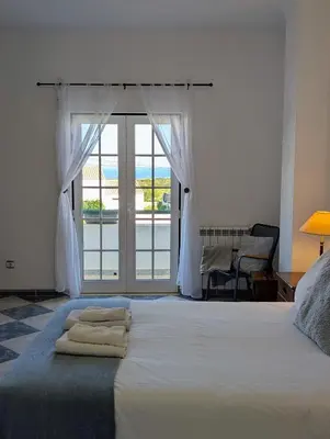 a bedroom with two beds and a window at Casa Machado in Sagres