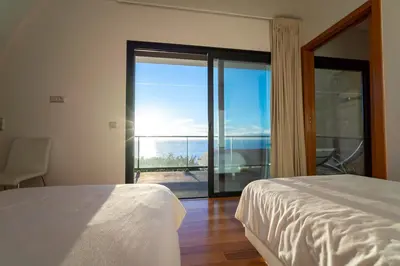 a bedroom with a bed and a view of the ocean at Beach Sunset Villa 100m from Ocean & Beach in Paul do Mar