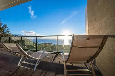 two chairs sitting on a balcony with a view of the ocean at Beach Sunset Villa 100m from Ocean & Beach in Paul do Mar
