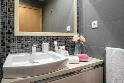 a bathroom with a white sink and a mirror at Luxurious Apartment Funchal - Casa Valentina - Rent2U, Lda in Funchal