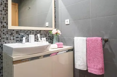 a bathroom with a sink and a mirror and pink towels at Luxurious Apartment Funchal - Casa Valentina - Rent2U, Lda in Funchal