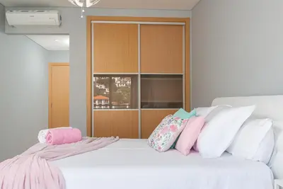 a bedroom with a white bed with pink and white pillows at Luxurious Apartment Funchal - Casa Valentina - Rent2U, Lda in Funchal