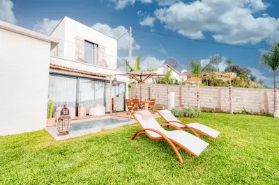 a yard with two lounge chairs and a pool at CASA 61 by Stay Madeira Island in Ponta do Sol