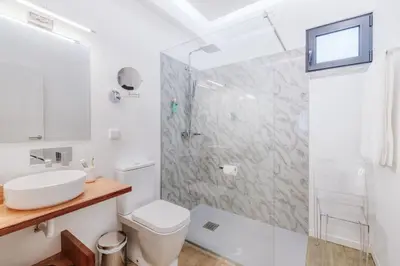 a white bathroom with a sink and a shower at CASA 61 by Stay Madeira Island in Ponta do Sol