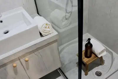 a white bathroom with a sink and a shower at Casa da Julia e Alice, a Home in Madeira in Funchal